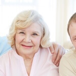 Portrait of senior and young couples with their children looking at camera at home